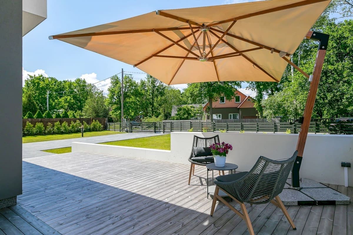 Beige Scandipro Ultra SA sidostolpsparasoll på modern terrass med svarta detaljer