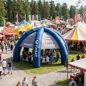 Stort blått uppblåsbart tält på festival med besökare inuti